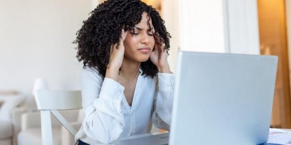 Adult sitting in front of the desk with migraine