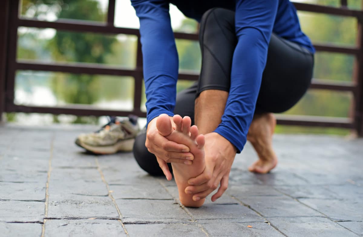 Runner's Guide to Prevent Pain runner holding her foot with painful stress fracture