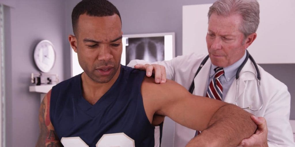 doctor treating athlete's back pain