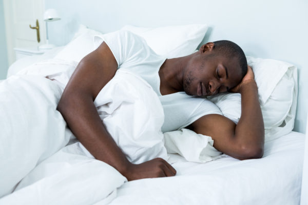 Black man sleeping chronic pain and sleep debt